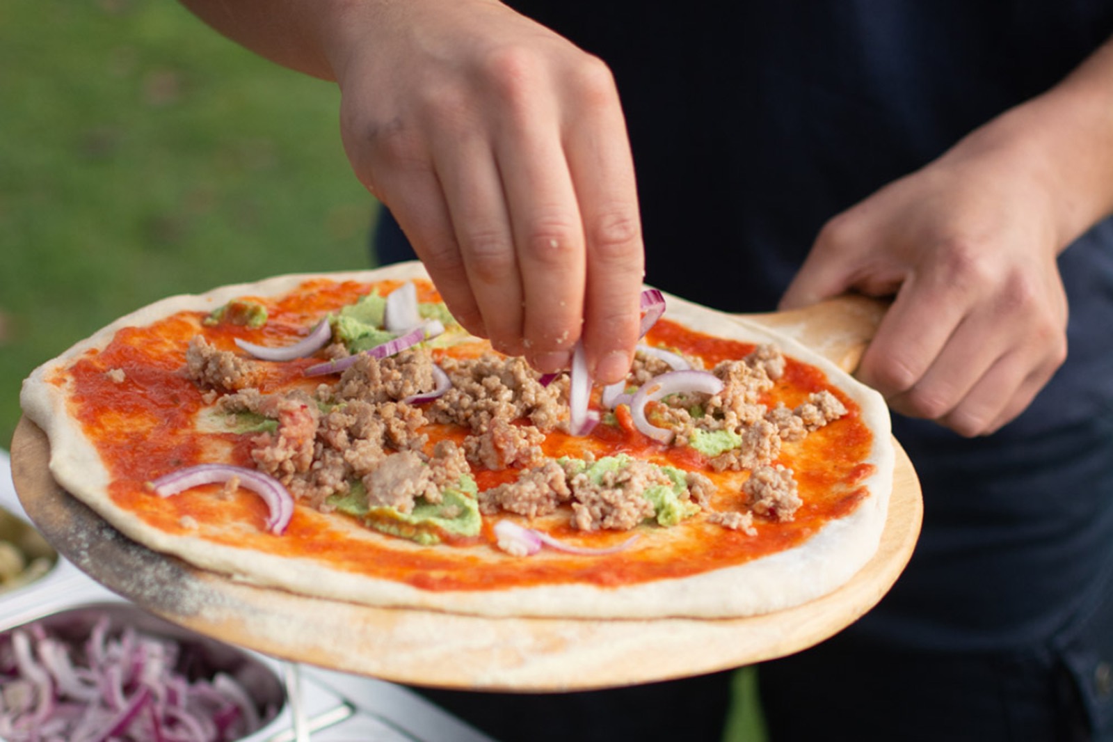Pizza wordt belegd
